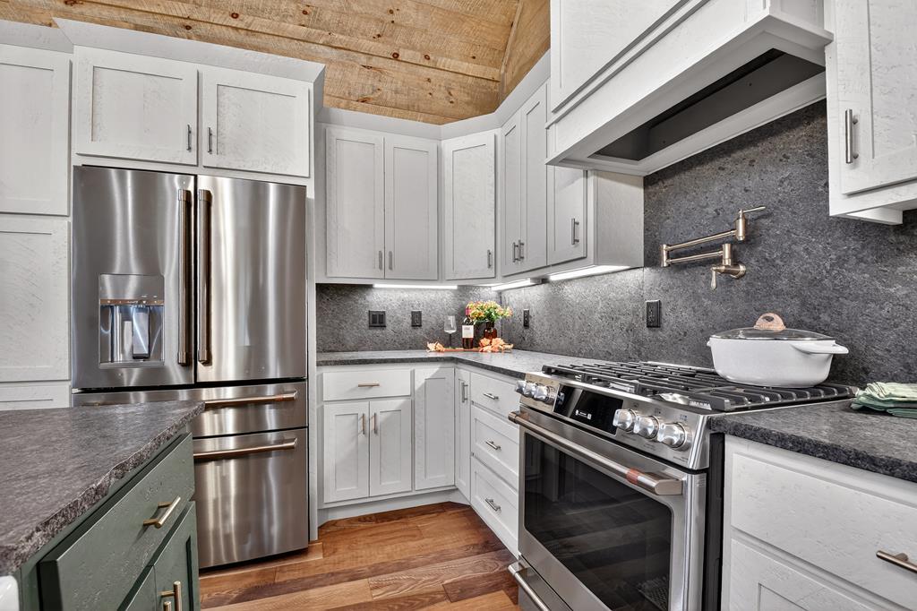 1204 Settler's Ridge Road Ellijay, GA 30540 - Photo 7 of 62 a kitchen with granite countertop a sink stove and refrigerator