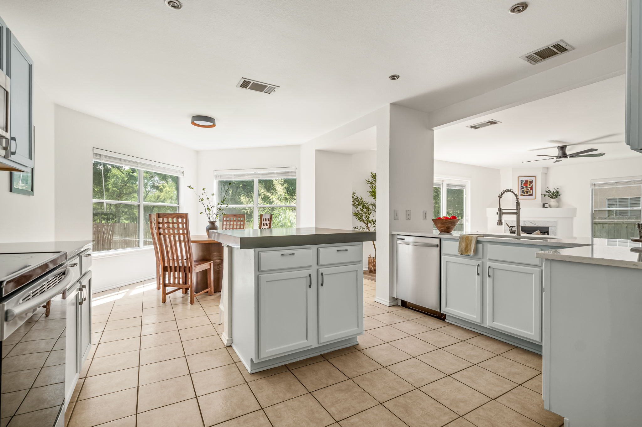 1408 Water Spaniel Way Round Rock, TX 78664 - Photo 11 of 37 A well-appointed kitchen features a central island and a casual dining area, illuminated by ample natural light.