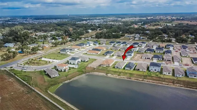an aerial view of a house with a yard and lake view
