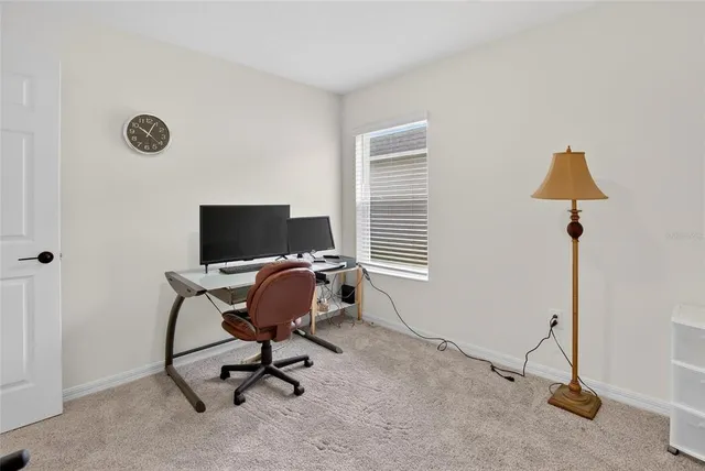 a view of a workspace with furniture and a window
