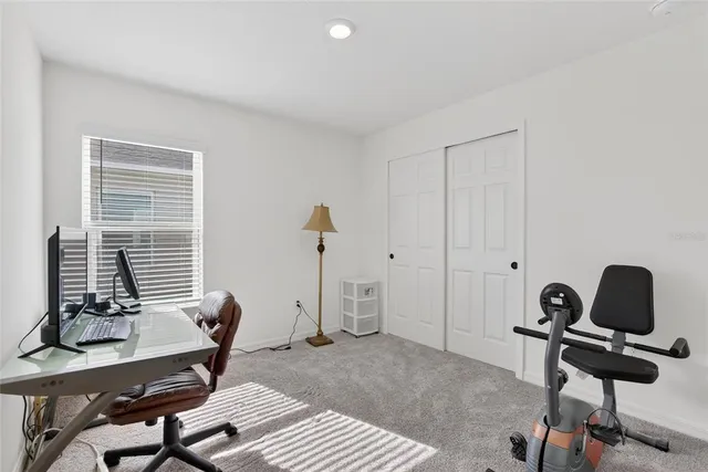 a view of a workspace with furniture and a window