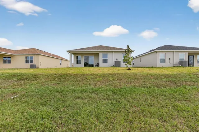 a view of a house with a big yard and large trees