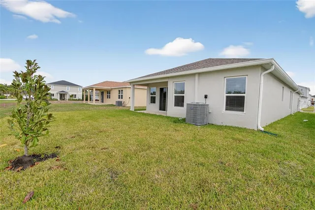 a view of a house with a yard and potted plants