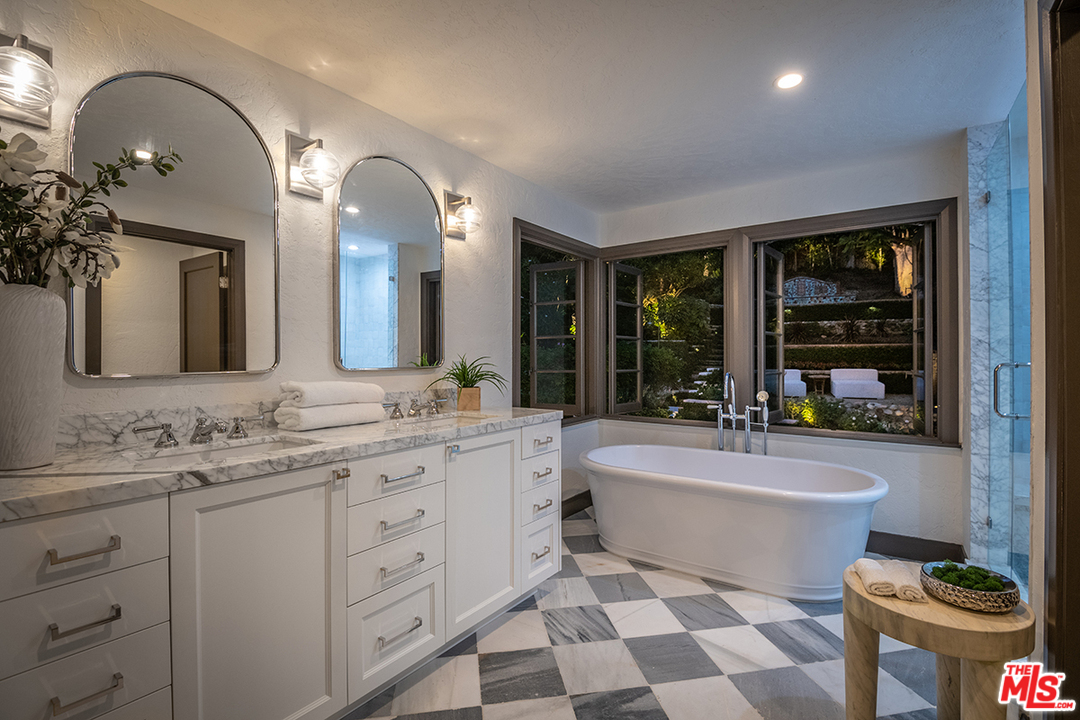 2426 Chislehurst Drive Los Angeles, CA 90027 - Photo 39 of 43 a spacious bathroom with a double vanity sink a mirror a bathtub and a window