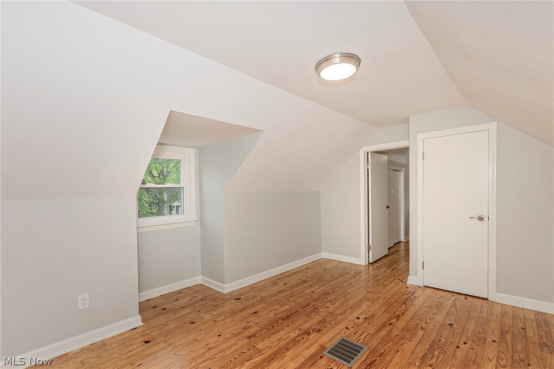 3719 Walter Road North Olmsted, OH 44070 - Photo 33 of 35 Attic space featuring wood-finish flooring, a window providing natural light, a flush-mount ceiling light fixture, and white trim