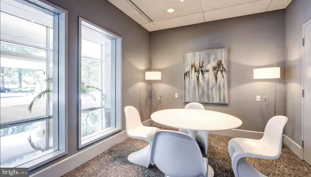 a living room with furniture a lamp and a large window