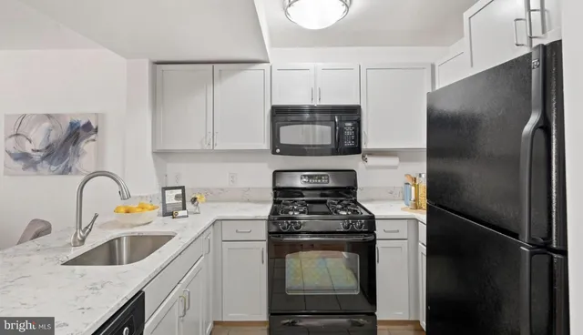 a kitchen with stainless steel appliances a refrigerator sink and white cabinets