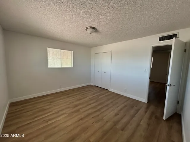 an empty room with wooden floor and closet