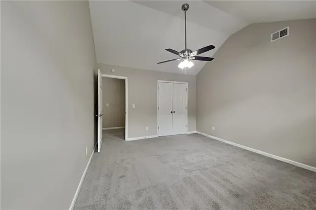 an empty room with a ceiling fan and a window