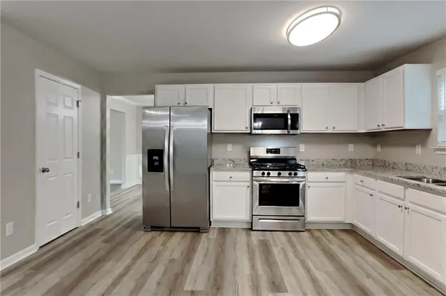 a kitchen with stainless steel appliances granite countertop a stove a sink and a refrigerator