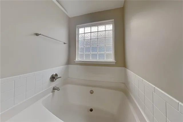 a white bath tub sitting in a bathroom next to a window