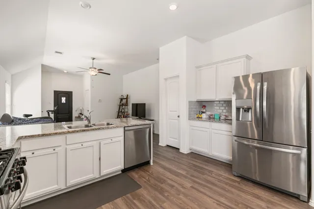 a kitchen with white cabinets and stainless steel appliances