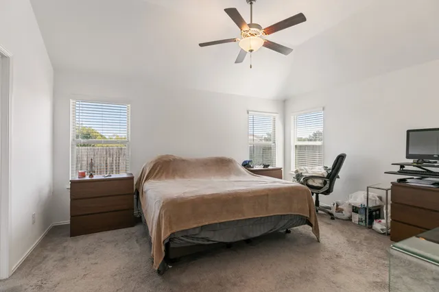 a bedroom with a bed a chair and a chandelier