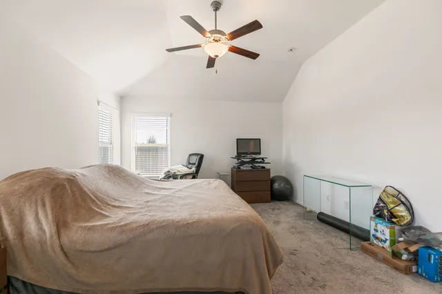 a bedroom with a bed and ceiling fan