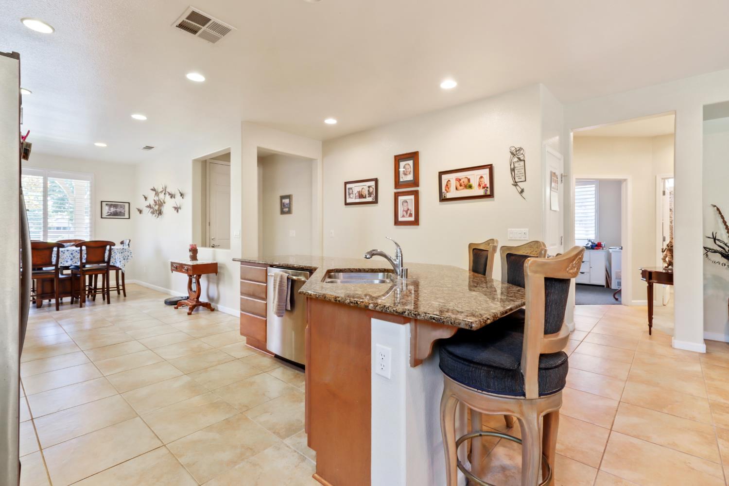 7401 Rothschild Court Elk Grove, CA 95757 - Photo 7 of 42 a living room with furniture a dining table and chairs