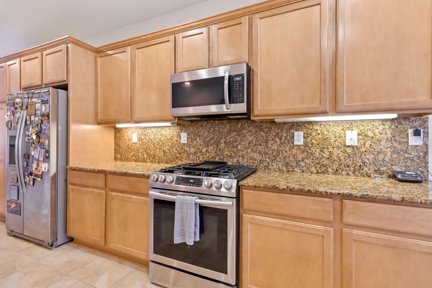 7401 Rothschild Court Elk Grove, CA 95757 - Photo 10 of 42 a kitchen with stainless steel appliances granite countertop white cabinets and a stove top oven