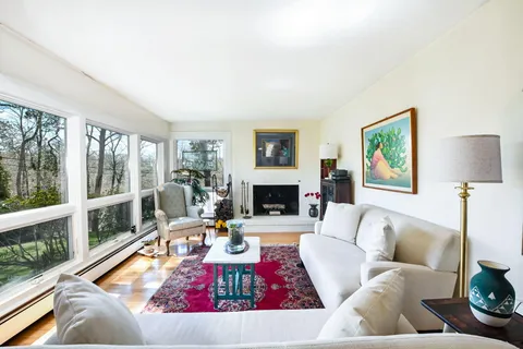 a living room with furniture fireplace and a large window