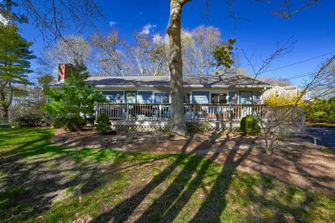 a view of a house with backyard garden and sitting area