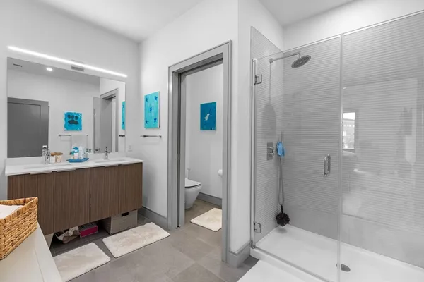 a bathroom with a double vanity sink toilet and shower