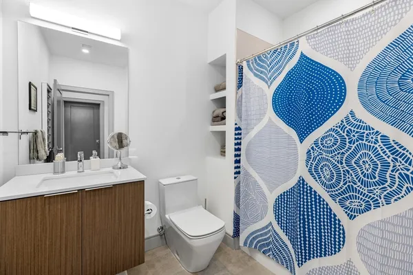 a bathroom with a toilet sink and mirror