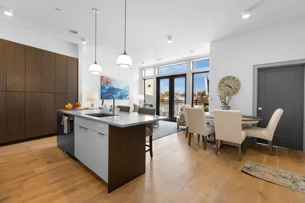 a living room with stainless steel appliances granite countertop a sink dishwasher a couches with the kitchen island