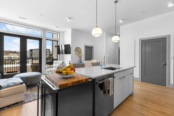 a view of a kitchen with a sink and dishwasher with wooden floor