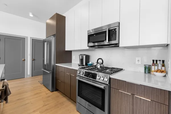 a kitchen with stainless steel appliances a sink dishwasher a stove and a microwave oven with cabinets