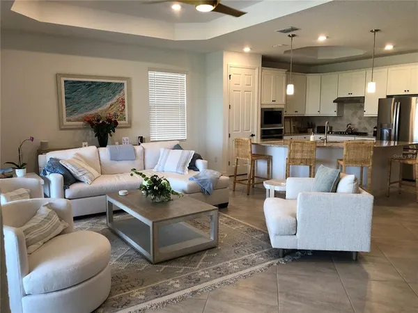 a living room with furniture and a view of kitchen