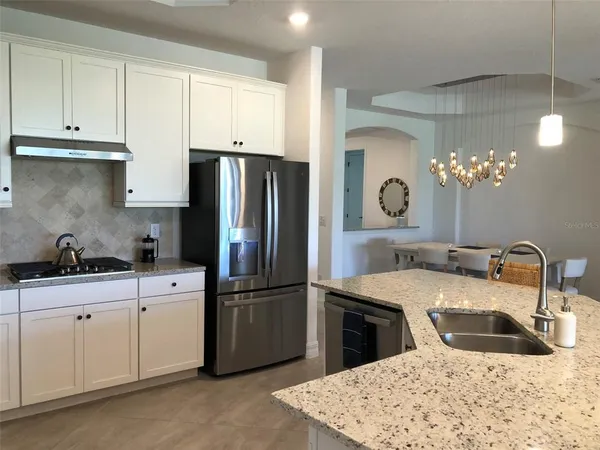 a kitchen with stainless steel appliances granite countertop a sink a refrigerator and a stove