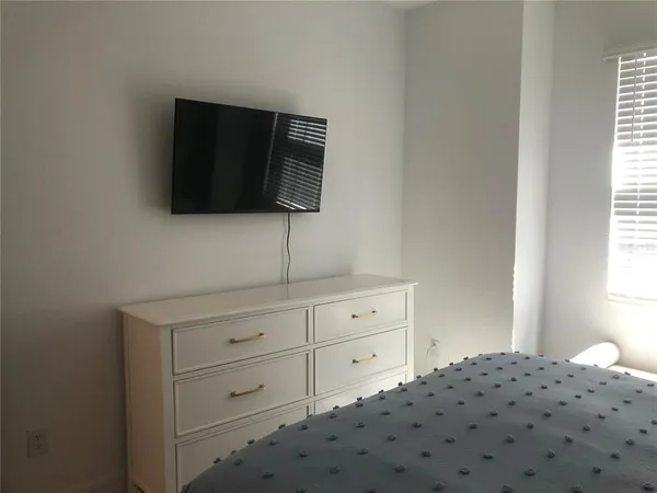 a bedroom with a bed and a television