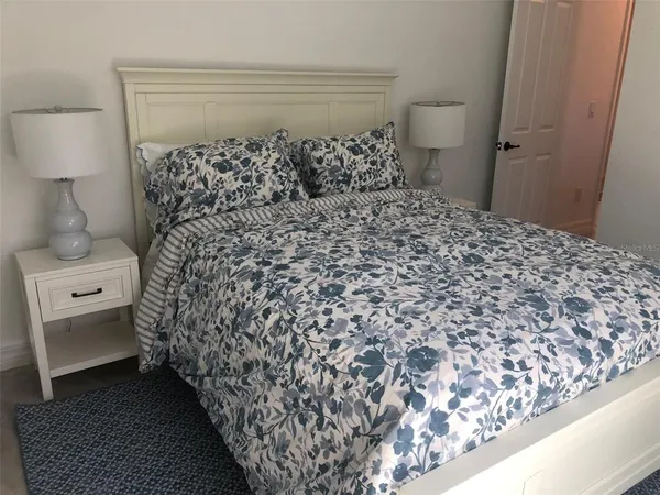 a bed sitting in a bedroom next to a window with a chandelier