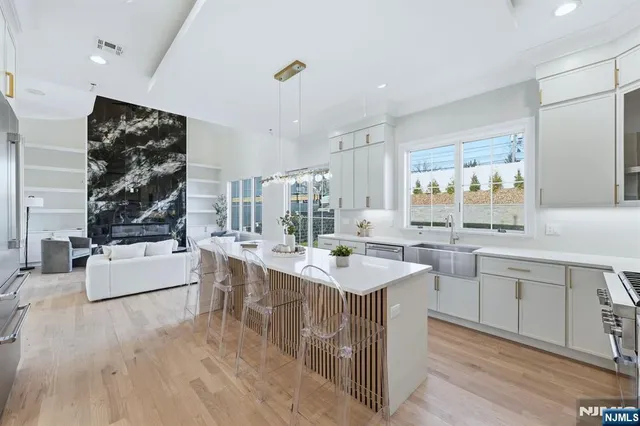 a large white kitchen with a lot of counter space and a wooden floor