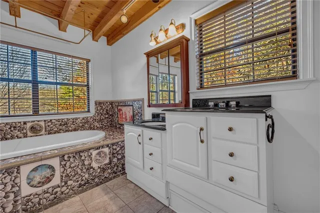a utility room with stainless steel appliances cabinets and a window