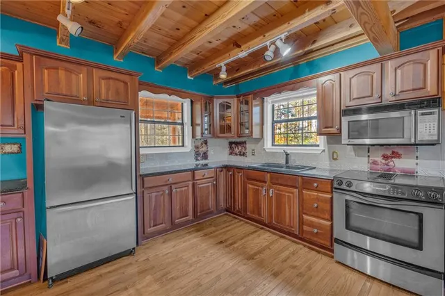 a kitchen with stainless steel appliances granite countertop a refrigerator a sink dishwasher stove and oven