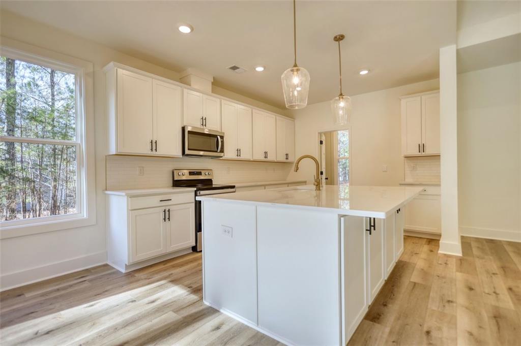 160 Loyd Road Mansfield, GA 30055 - Photo 35 of 82 a kitchen with granite countertop a stove top oven a sink a window and white cabinets