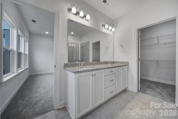 a bathroom with a granite countertop sink a large mirror and a shower