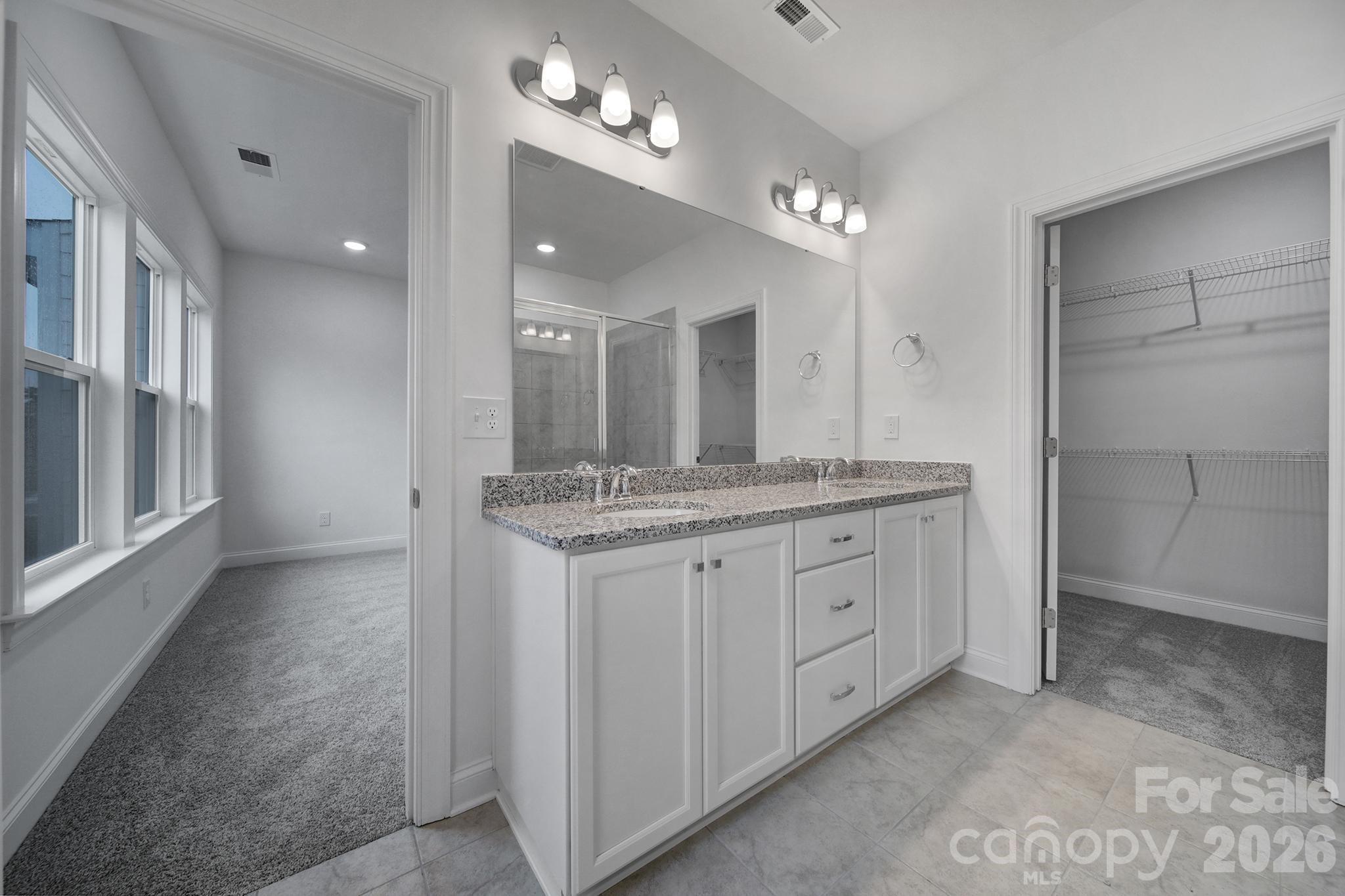 9220 Walnut Hl Road Northwest Concord, NC 28027 - Photo 12 of 14 a bathroom with a granite countertop sink a large mirror and a shower