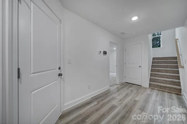 a view of a hallway with wooden floor and entryway