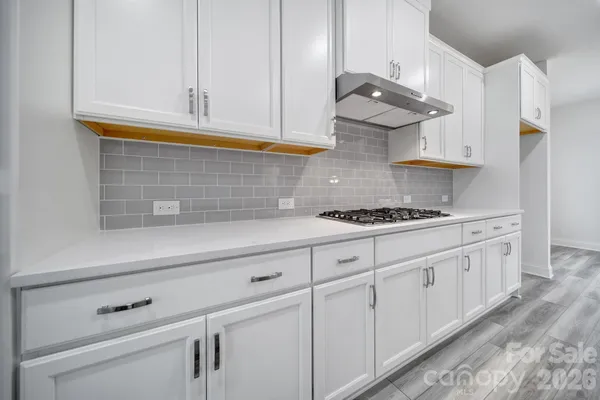 a kitchen with white cabinets and a stove