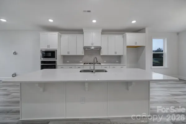 a kitchen with kitchen island a sink stainless steel appliances and cabinets