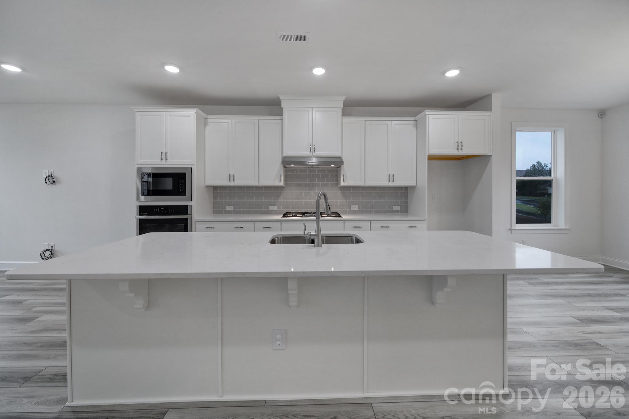 9220 Walnut Hl Road Northwest Concord, NC 28027 - Photo 8 of 14 a kitchen with kitchen island a sink stainless steel appliances and cabinets