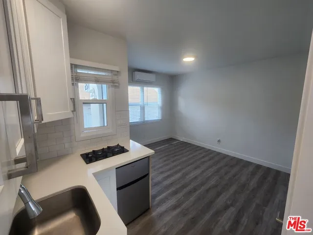 a kitchen with granite countertop a stove and a wooden floor