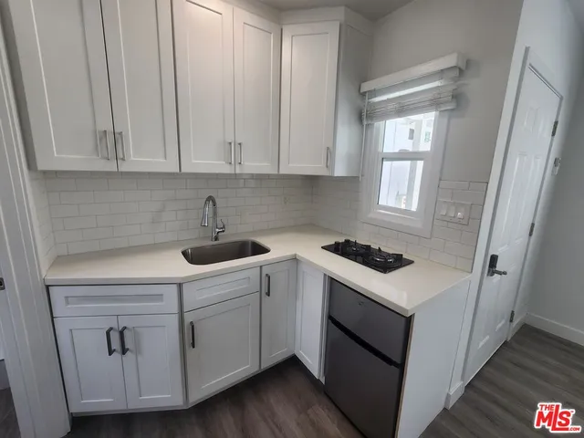 a kitchen with white cabinets and white appliances