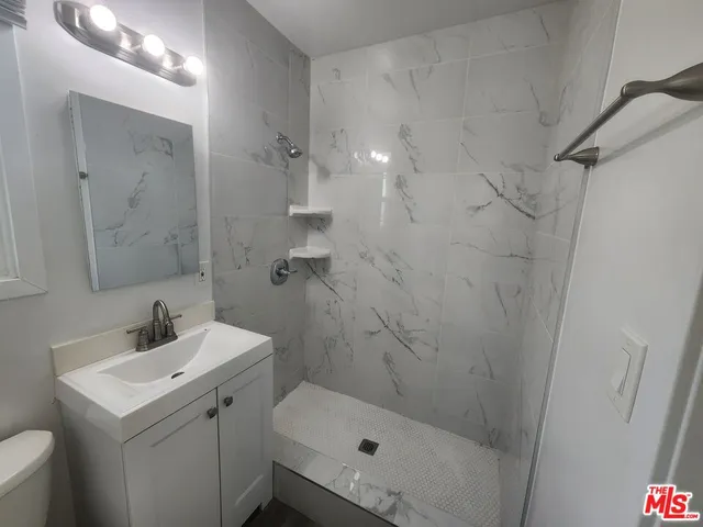 a bathroom with a sink a toilet and shower