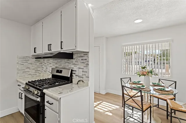 a kitchen that has a stove and a table chair in it