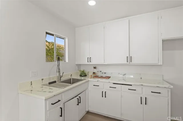 a kitchen with a sink window and cabinets