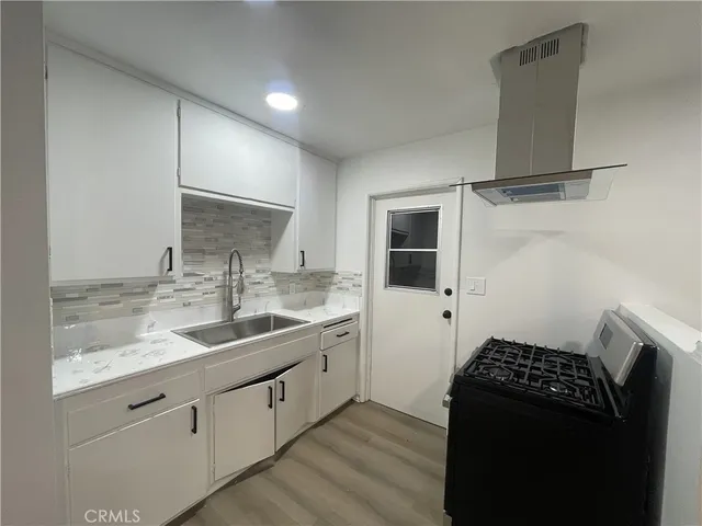 a kitchen with a sink and a stove top oven
