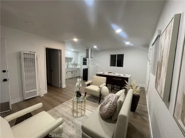 a living room with furniture wooden floor and a large window