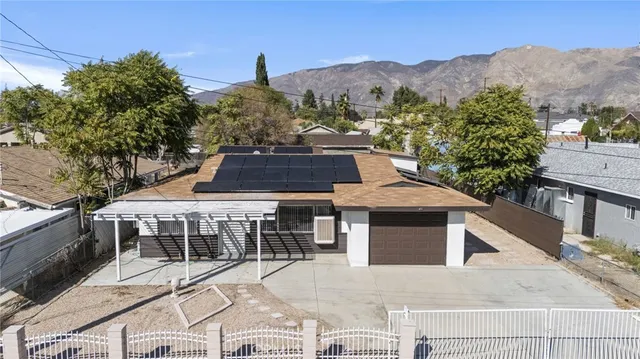 a front view of a house with a yard and mountain view