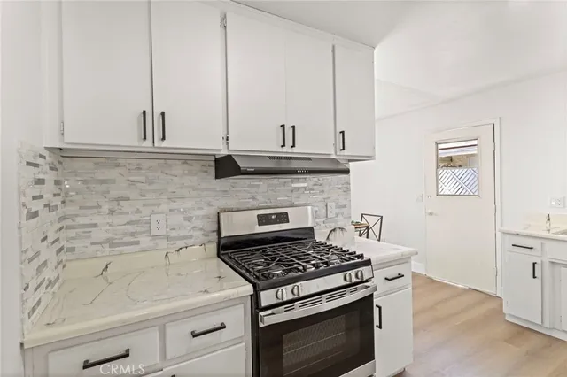 a stove top oven sitting inside of a kitchen